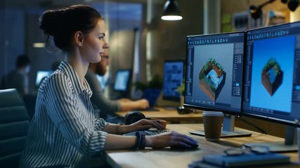 Wall Mural - female game developer works on a level design on her personal computer with two displays. she works 