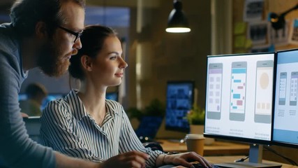 Wall Mural - female ux architect has discussion with male design engineer, they work on mobile application late a