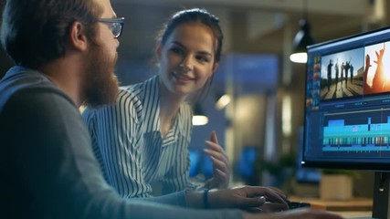 Wall Mural - female and male video editors work with footage and sound on their personal computer with two displa