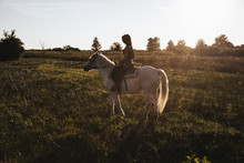 Young Woman Riding A White Horse