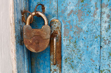 Old Closed Padlock Rusty On Wooden Weathered Door/An Old Wood Blue Painted Door With Metal Rusted Latch, Padlock And Antique Door Handle.Vintage Lock