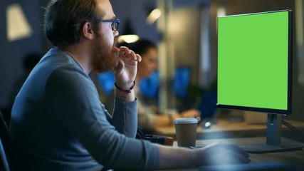 Wall Mural - creative bearded man works on a personal computer with isolated mock-up green screen. his office spa