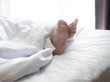 © anon - Feet of sleeping woman in white bed room.feet of a young woman lying in bed close up.