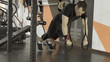 © lenblr - Sportsman wearing black shorts and t-shirt exercising with fitness straps in gym