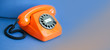 © besjunior - Orange phone blue background. Retro style plastic handset receiver communication call center concept. Shallow depth field. copy space template
