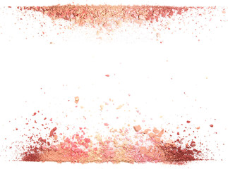 Samples of dry blush, powder, bronzers and highlighter scattered in a line isolated on a white background