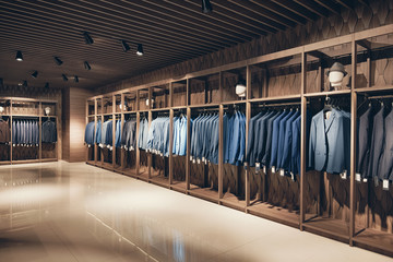 interior of the business suit shop. strict premium expensive suits hang in a row on hangers in large