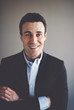 © Flamingo Images - Confident young executive standing with his arms crossed smiling