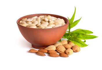 Wall Mural - Blanched almonds In a bowl with unshelled nuts. On white background.