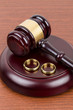 Wooden judge gavel and golden rings divorce concept