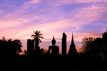 Buddha statue in Wat Maha That at sun set silhouette, Shukhothai Historical Park, Thailand