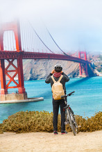 San Francisco Golden Gate Bridge Biking Tourist With Bicycle Taking Pictures Of View On West Coas, California, United States Of America. USA Travel People Lifestyle.