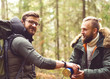 © Acronym - Camp, adventure, traveling and friendship concept. Man with a backpack and beard and his friend hiking in forest. Autumn color and hipster filter.
