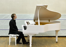 Young Pianist Sits In Front Of White Grand Piano