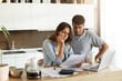 © WHstudio Leushin N - Picture of young wife and husband in kitchen having concentrated looks while reading notification from bank concerning their loan application. Caucasian couple calculating expenses in the morning