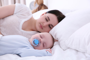 Poster - Young woman with cute baby sleeping on bed