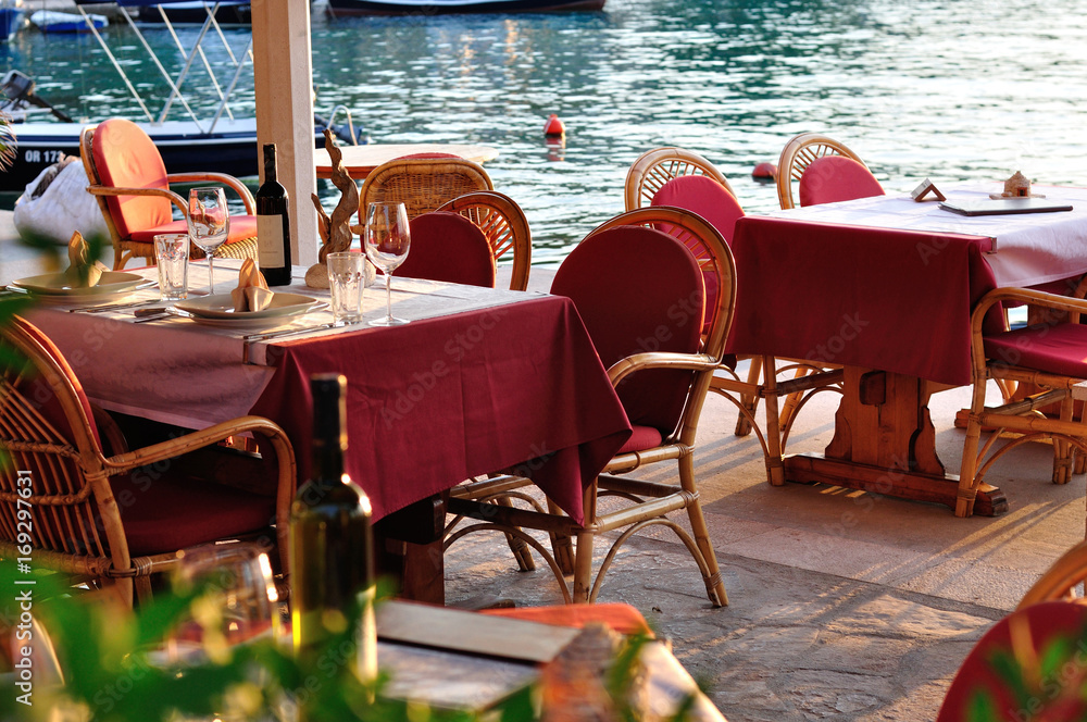 Stoliki restauracyjne nad brzegiem zatoki w Chorwacji. - obrazy, fototapety, plakaty 