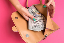 Woman's Hand Removing Money From Little Bag, Studio Shot