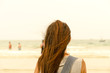 © Phanithi - The traveler stand on the sand beach and look people are swimming, The backside head of traveler stand on the sand beach