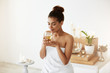 © Cookie Studio - Attractive african girl drinking green tea resting in spa salon. Closed eyes.