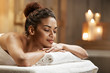 © Cookie Studio - Beautiful african girl resting relaxing in spa resort with closed eyes.