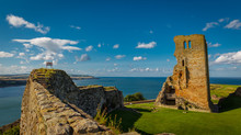 Wide Angle Shot Of The Medieval Scarborough Castle During Sunset Golden Hour Against A Bright Blue Sky, Yorkshire, England, UK