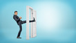 © gearstd - A businessman in side view kicks a small white door open with his leg on blue backgrounds.