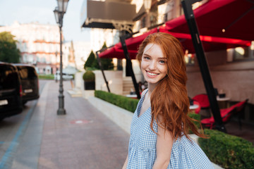 Sticker - Smiling redhead girl standing outside on a city street