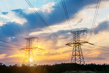 Electric transmission line in rice field during sunset.