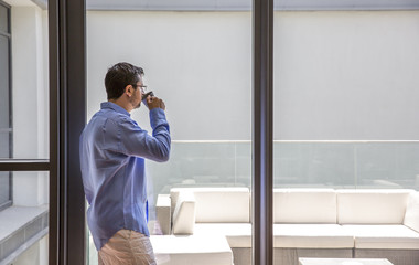 Wall Mural - arab man drinking coffee in his city apartment