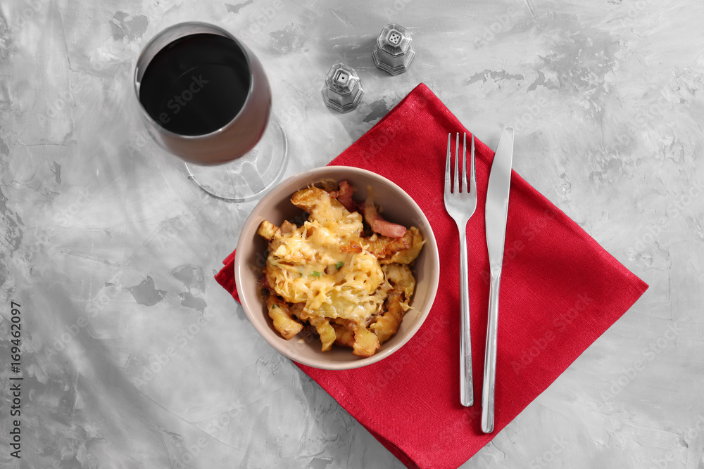 Bowl with tasty baked potato, bacon and cheese on table