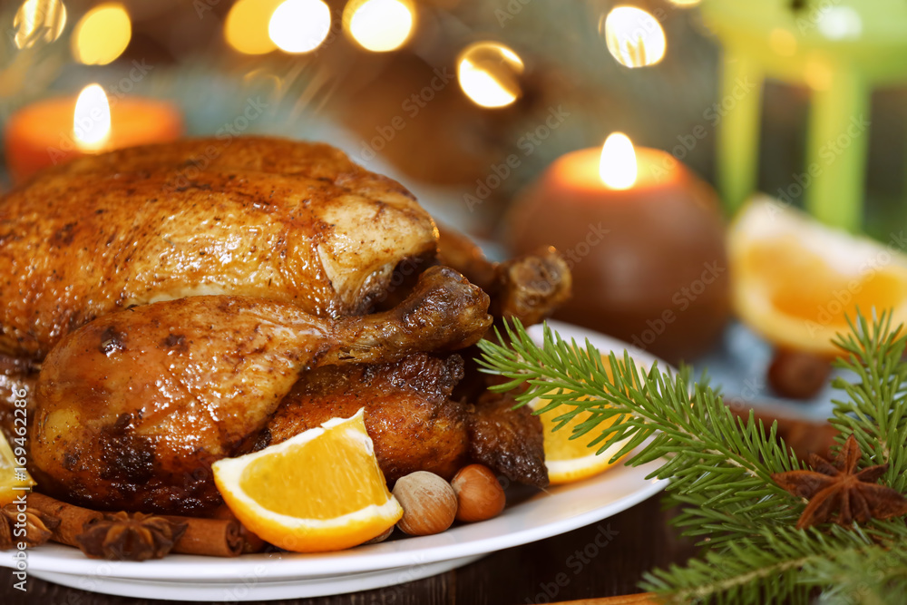 Plate with tasty whole roasted turkey on table against defocused lights