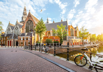 Wall Mural - Morning view on the water channel with Old Church during the sunny weather in Amsterdam city