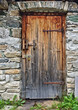 © Harald - Old wooden door in field stone wall with rusty hinges and padlock