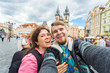 © satura_ - Happy young couple in love takes selfie portrait in Prague, Czech Republic. Pretty tourists make funny photos for travel blog in Europe.