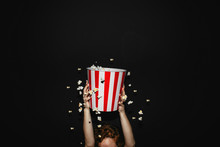 Girl Holding A Box Of Popcorn In Front Of The Black Background