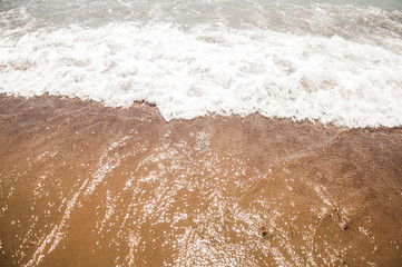 Sea beach in with white foam wave