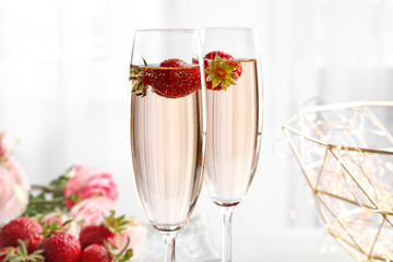 Canvas Print - Glasses of delicious wine with strawberry on table