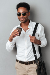 Poster - Man in sunglasses wearing a bag and holding coffee cup