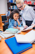 © LIGHTFIELD STUDIOS - teacher helping schoolgirl with homework