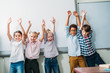© LIGHTFIELD STUDIOS - kids with raised hands next to whiteboard
