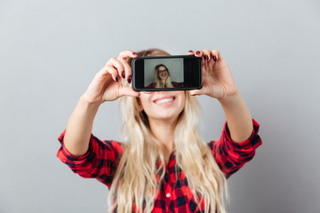 Canvas Print - Happy young blonde woman make selfie by phone.