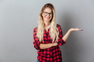 Canvas Print - Emotional smiling young blonde woman holding copyspace