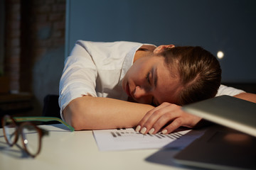 Exhausted manager or auditor sleeping by her workplace at night