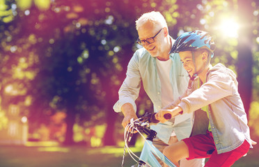 Wall Mural - grandfather and boy with bicycle at summer park