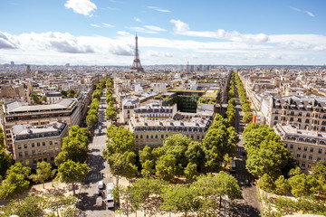 Wall Mural - Aerial wide angle cityscape view on the beautiful buildings and avenues with Eiffel tower on the background during the sunny day in Paris