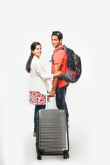 stock photo of smart Asian or Indian couple traveler with suitcase and hike bag isolated over white background, going abroad or within country, perfect shot for tours and travels company
