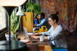 © BONNINSTUDIO/Stocksy - Side view of colleagues working on their desks in a creative office.