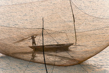 Vietnamese Fisherman On Boat Surrounded By Net