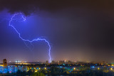 Fototapeta Tęcza - Lightning over the city at the summer storm. Dramatic, breathtaking atmospheric natural phenomenon.